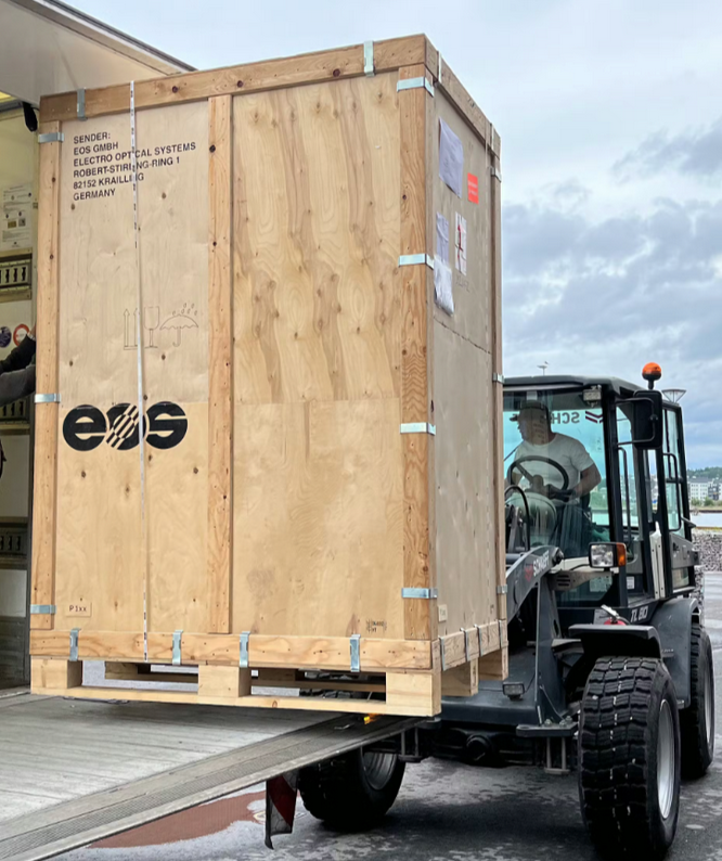 Large wooden equipment crate being unloaded at Norra AM’s production facility.