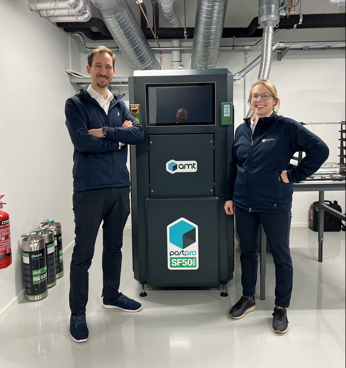 Stefano & Denise Chiabotti standing beside the AMT vapor smoothing equipment for additive manufacturing post processing