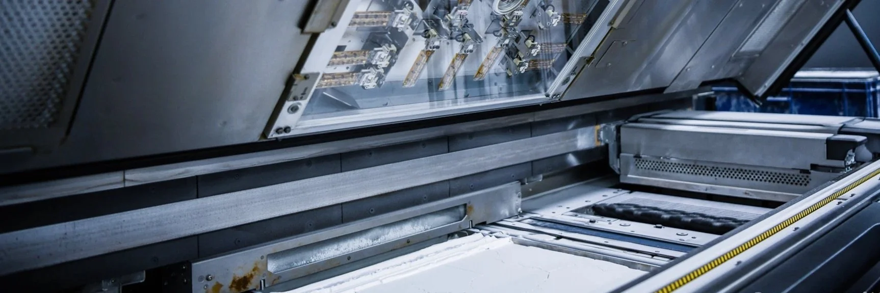 Inside view of a HP Multi Jet Fusion (MJF) 3D printing machine spreading and fusing powder during the build process.