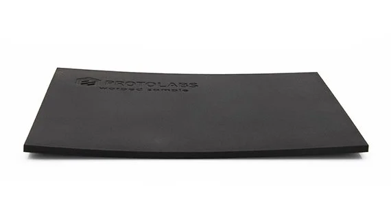 Veckad svart 3D-printad plastdel som visar deformation från termisk stress under printning.