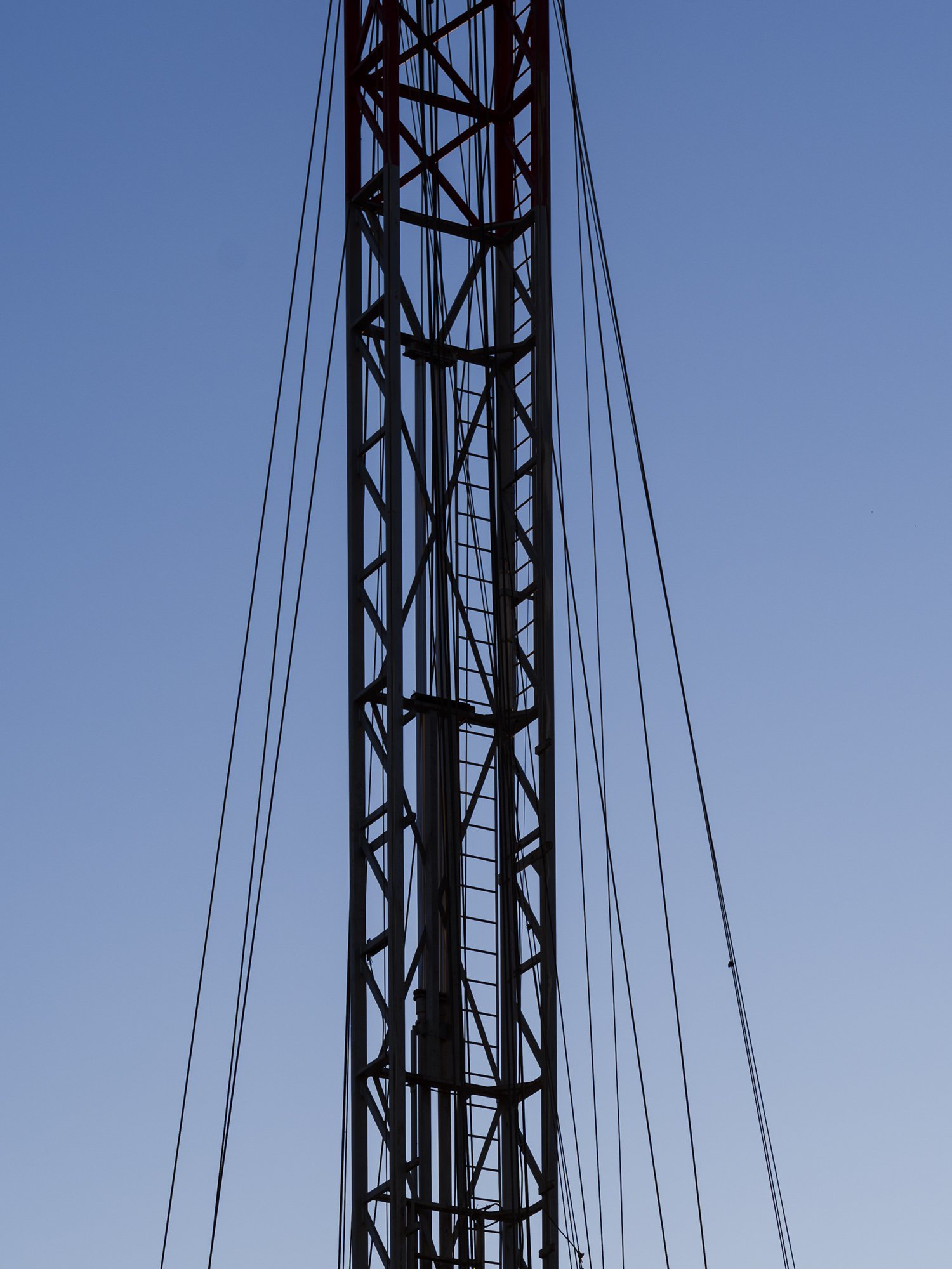A tall metal radio tower against a clear blue sky.
