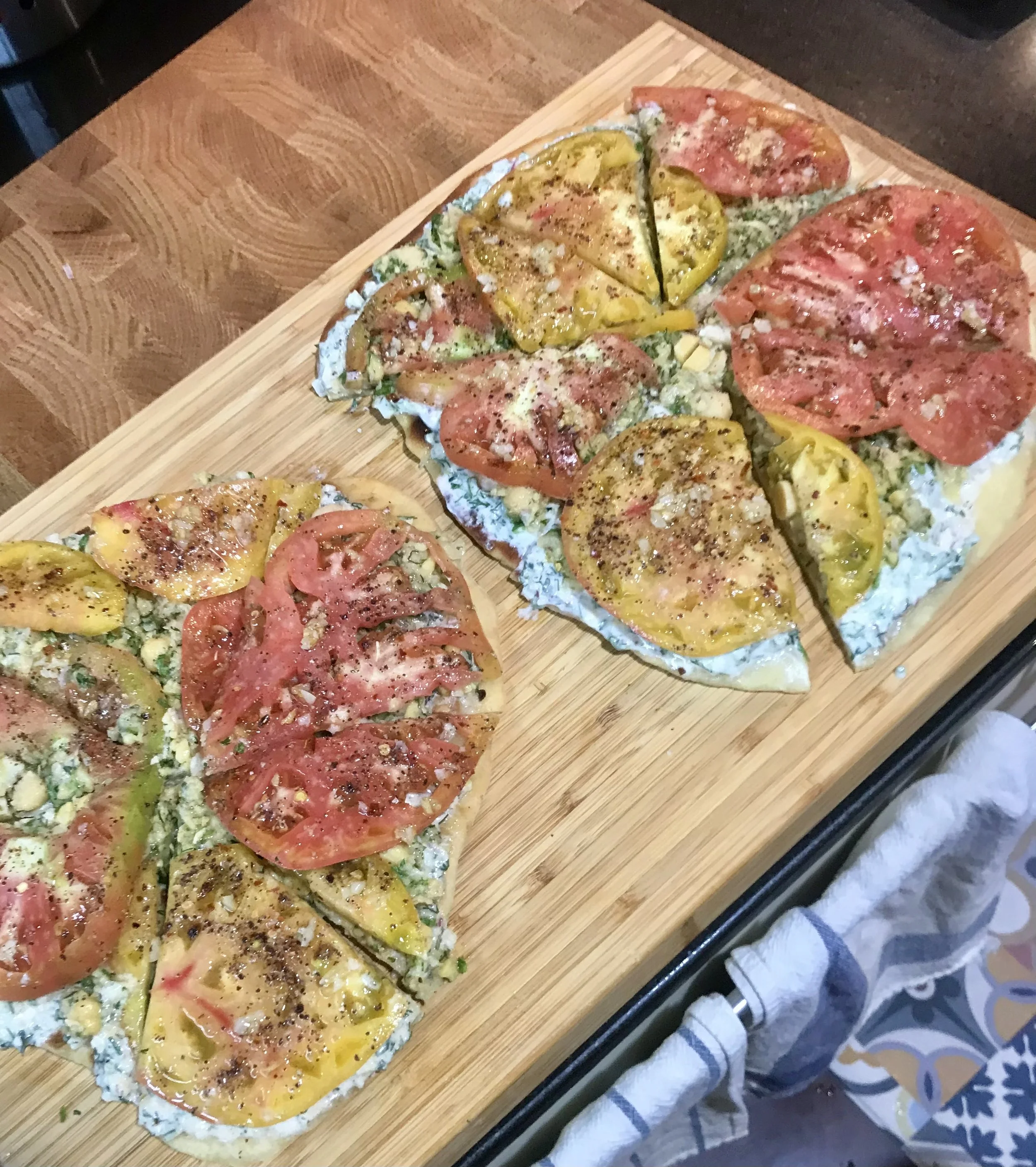 Tomato flatbreads on a wooden cutting board