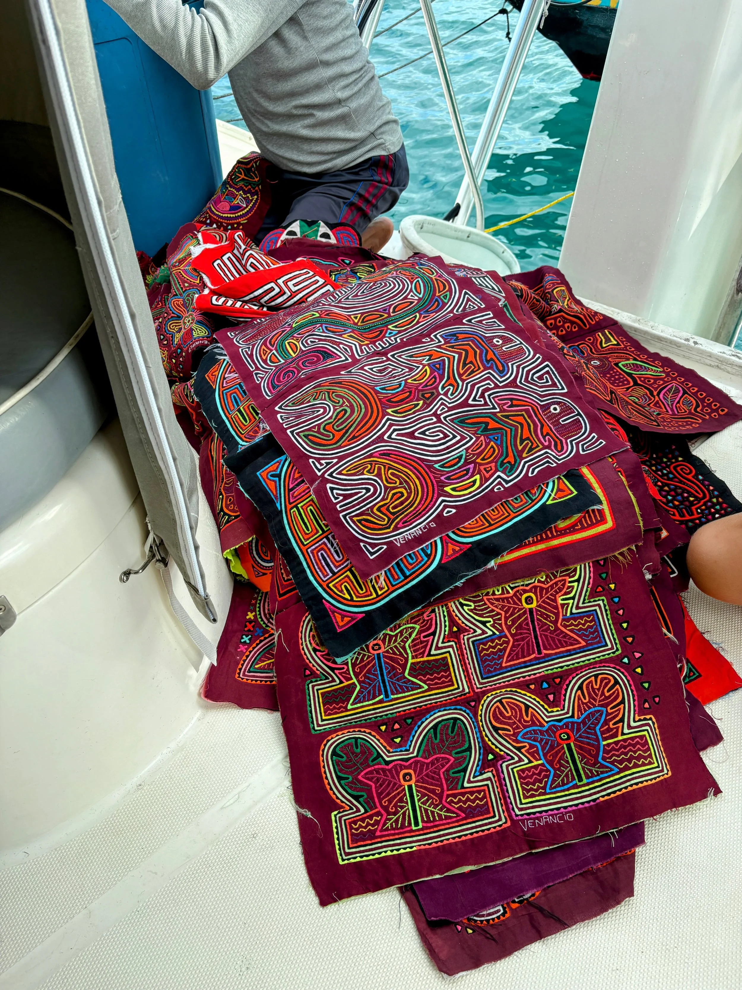 We invited this mola seller onto our boat (the women of his village actually make them) and every single one had a story to tell