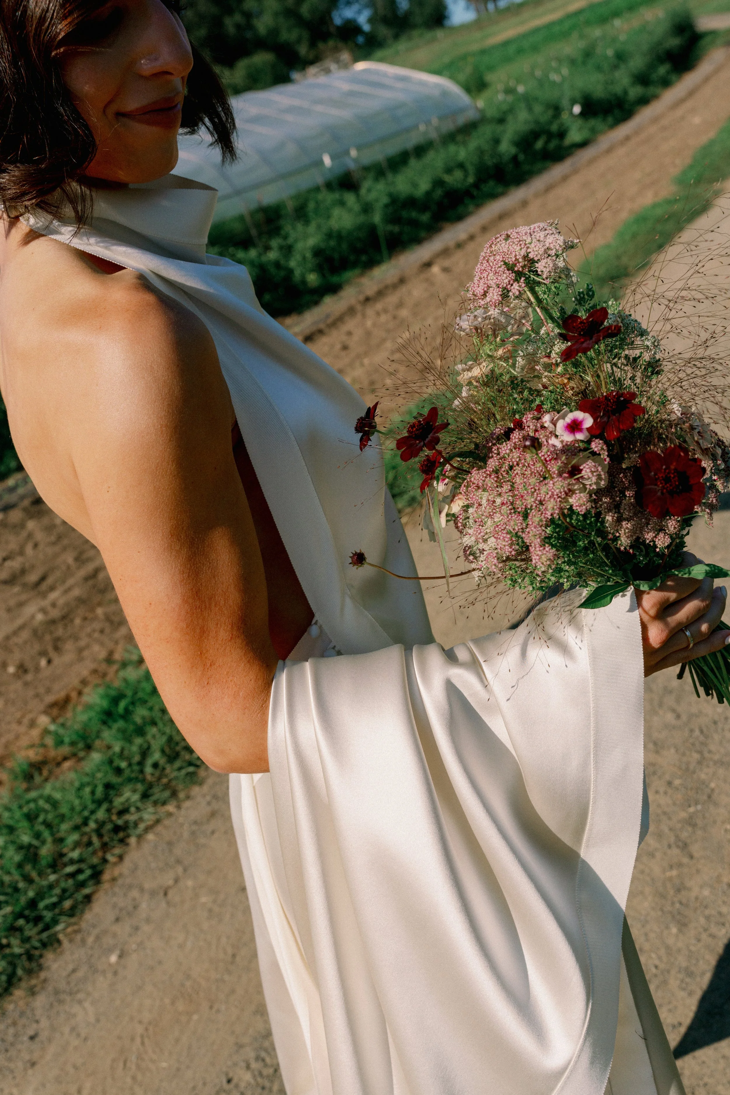 A wildflower inspired bridal bouquet held by the bride at blue hill at stone barns in the Hudson valley