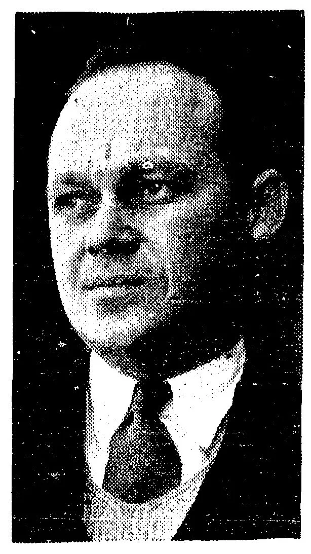Black-and-white portrait of Manfred DeAhna, wearing a suit and tie, looking to the side.