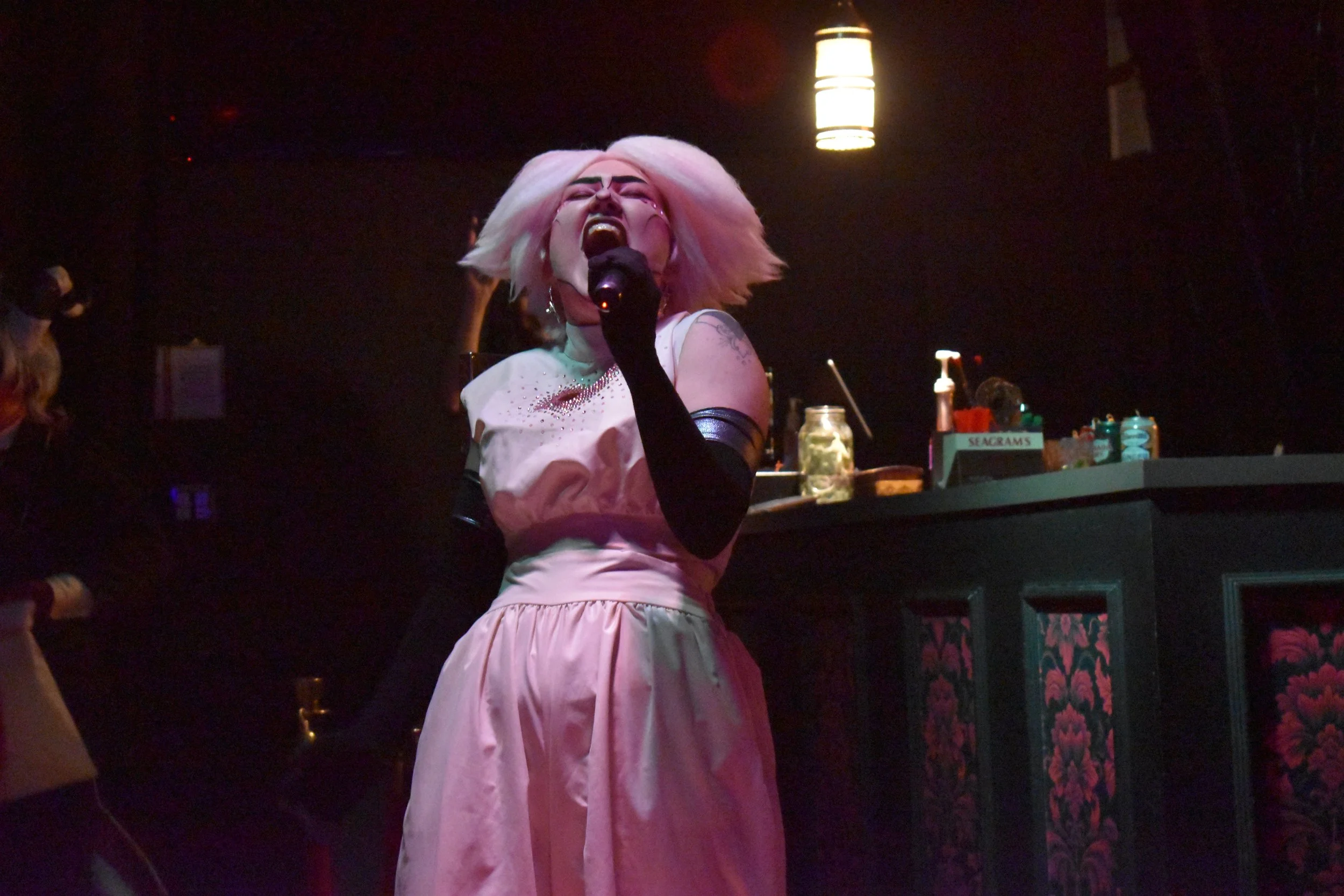 Black reveal dress, white rhinestone jumpsuit with heart cutout, wig. "Helluva Cabaret" (Newport Theater, '25)