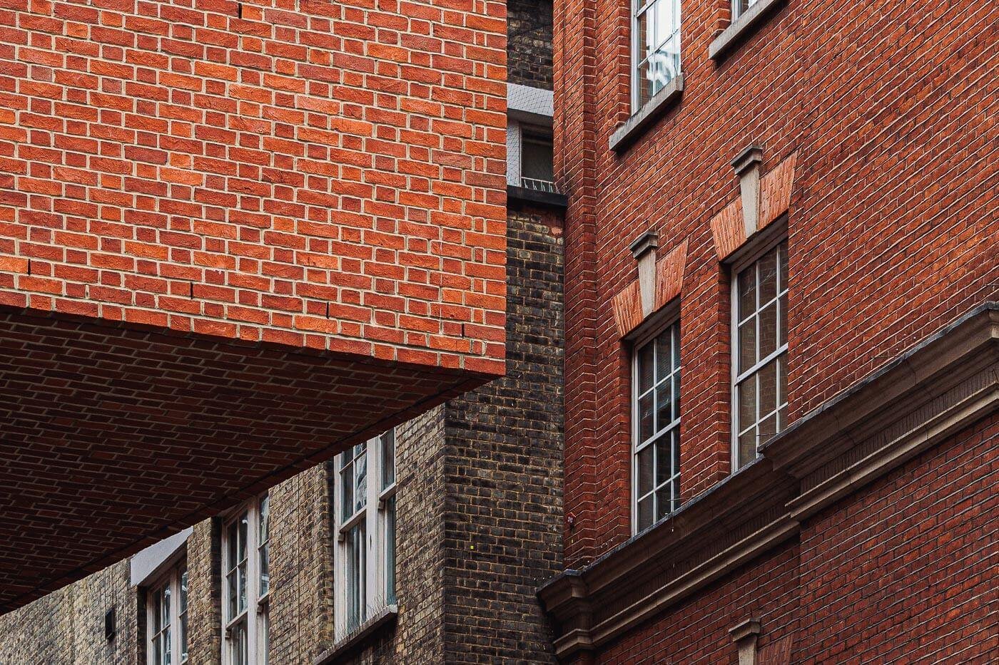 Architekturfotograf Hamburg: rote Backsteinfassaden in London mit Sprossenfenstern und auskragendem Baukörper
