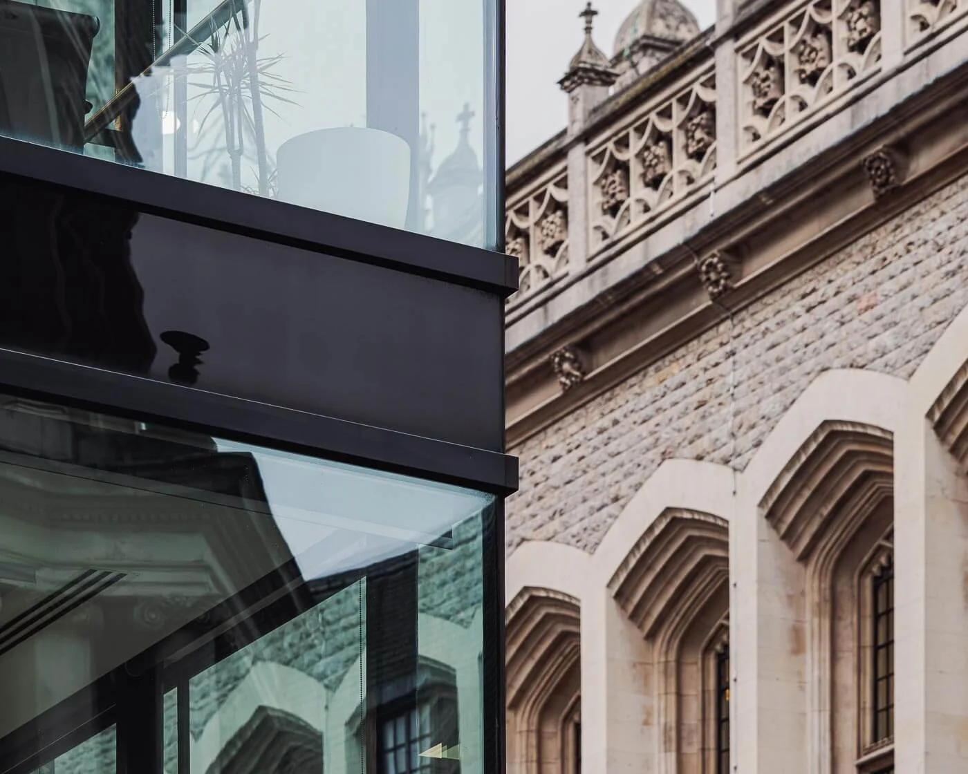 Architekturfotograf Berlin: Moderne Glasfassade in London im Kontrast zur neugotischen Steinfassade mit Maßwerk im Hintergrund