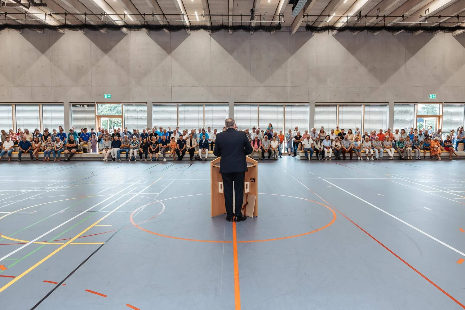 Eventfotografie Berlin: Rede des Bürgermeisters vor vollen Reihen bei der Eröffnung der Sporthalle am Lützelbach