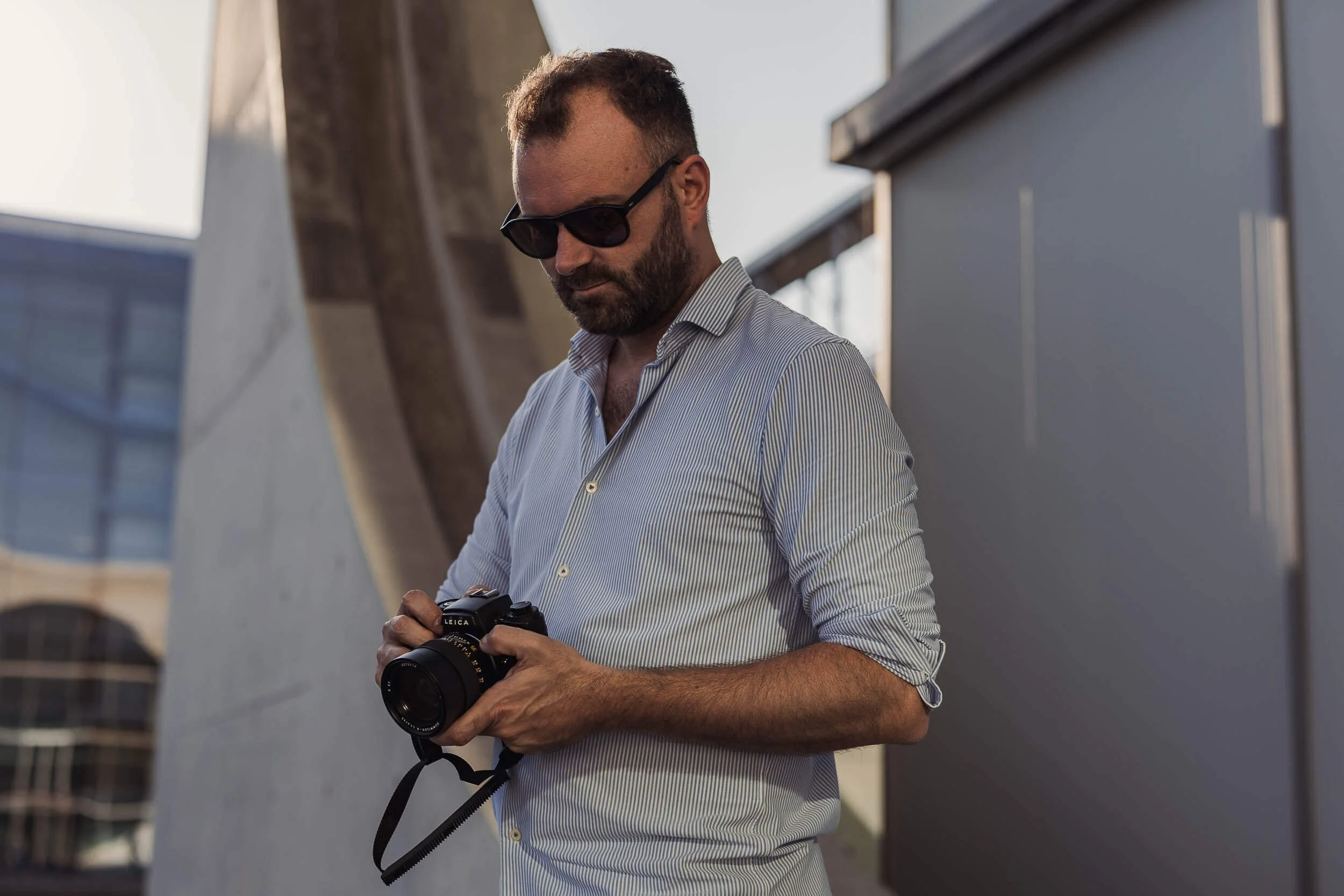Architekturfotograf Berlin: Maximilian von Alvensleben mit Leica-Kamera vor Sichtbetonarchitektur am Paul-Löbe-Haus
