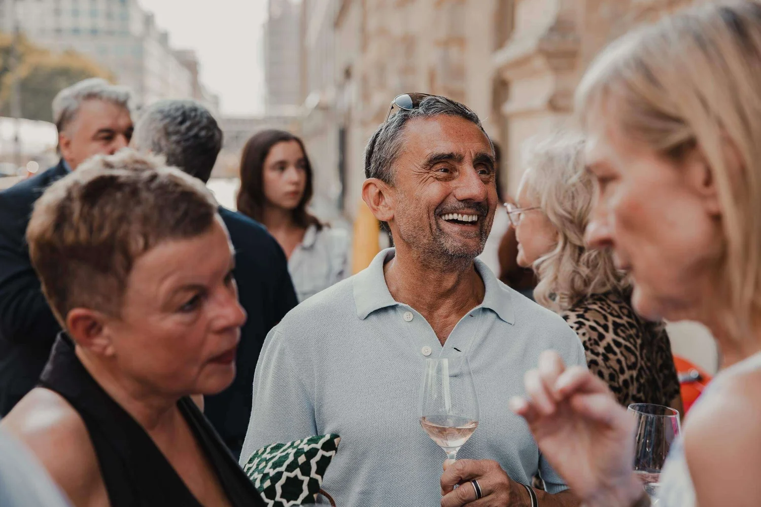 Eventfotograf Berlin: lachender Gast mit Weinglas bei der Vernissage La Dolce Vita