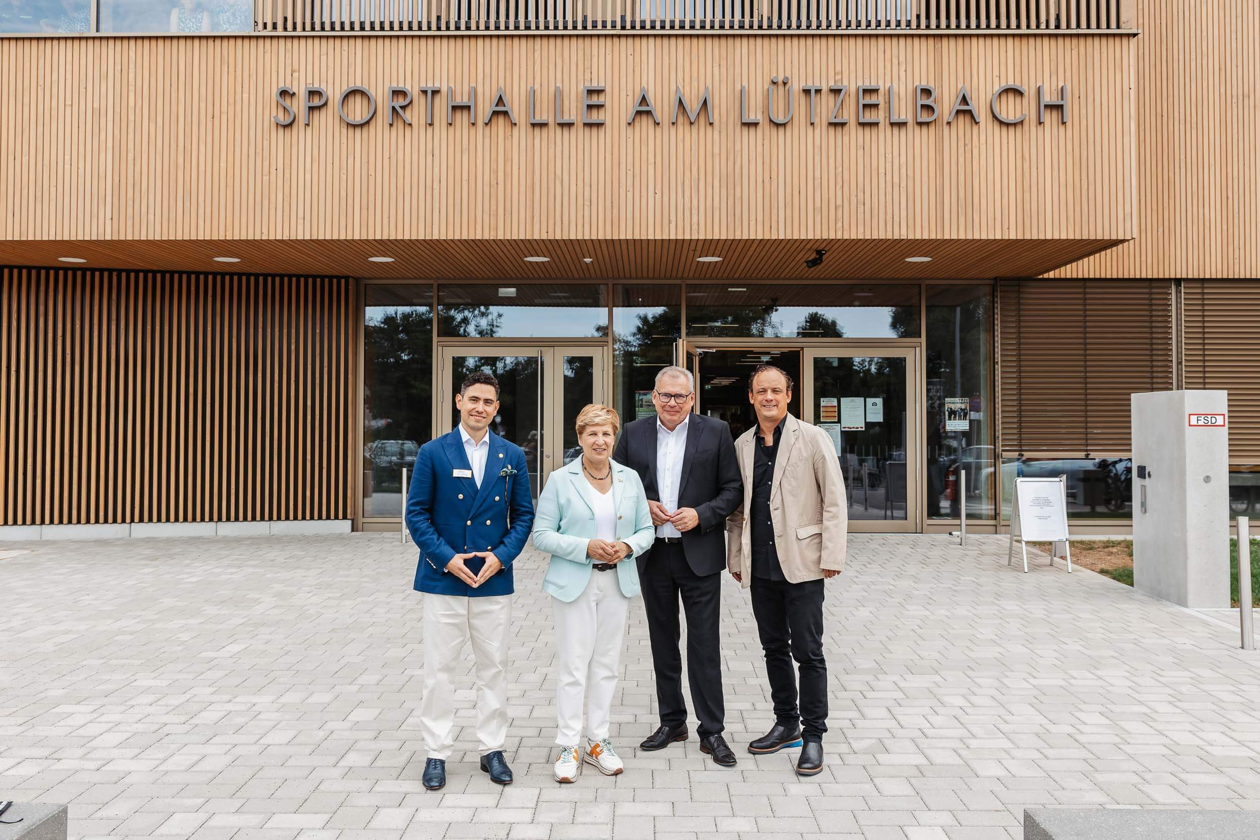 Eventfotograf Berlin: Gruppenbild vor dem Eingang der Sporthalle am Lützelbach mit Schriftzug