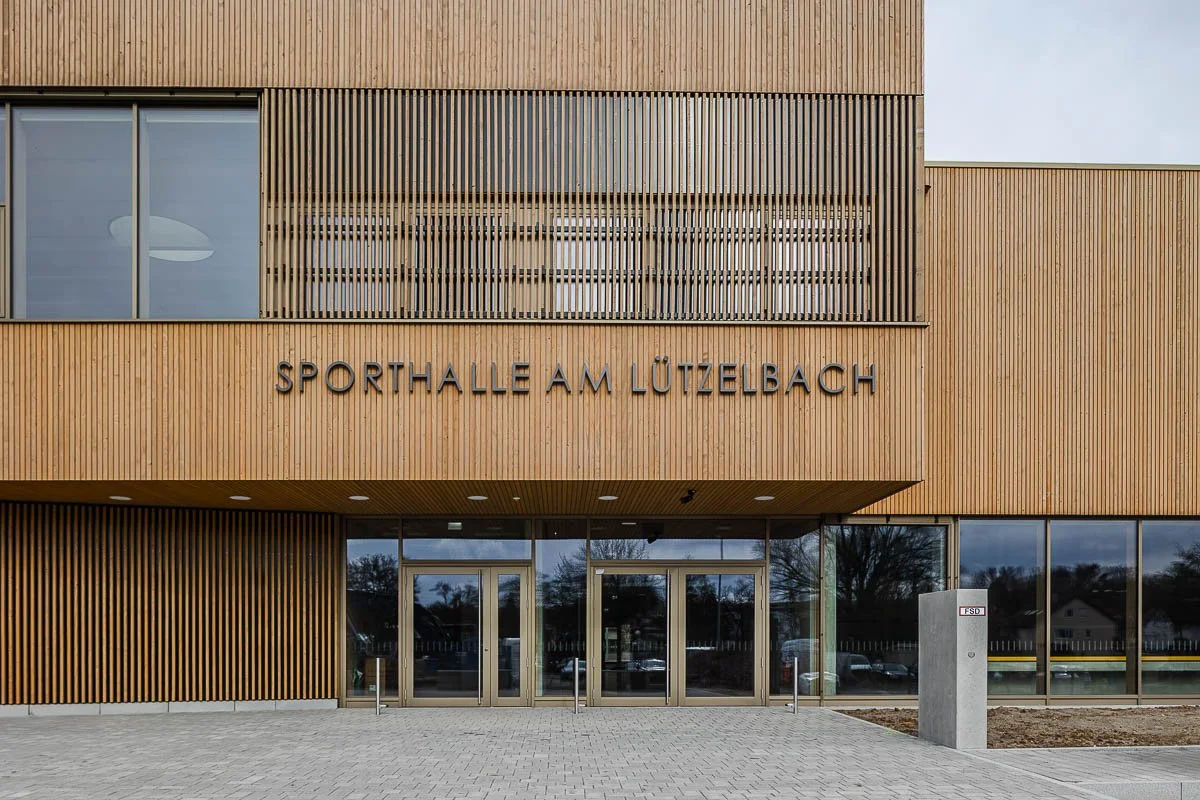 Architekturfotograf-Berlin-Sporthalle-am-Luetzelbach-Aussenfassade-Eingang-Schriftzug-Holzlamellen.jpg