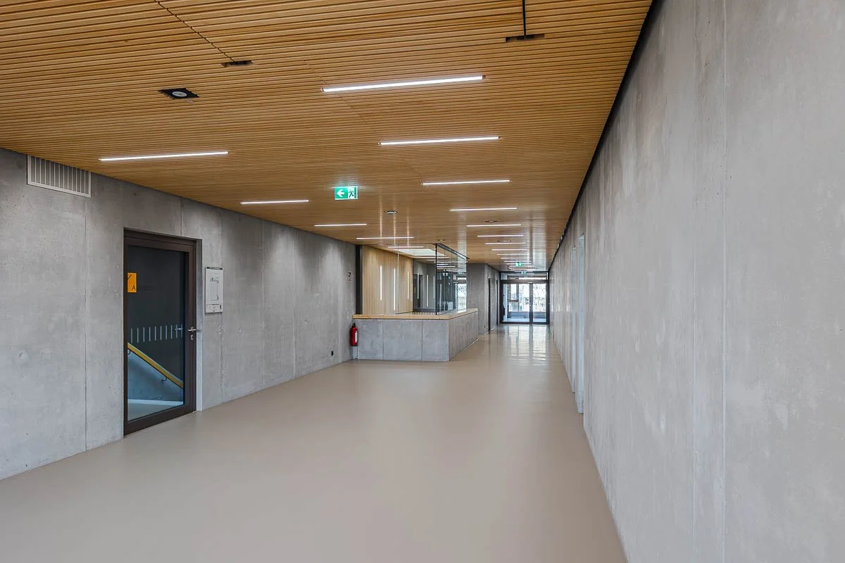 Architekturfotograf-Berlin-Sporthalle-am-Luetzelbach-Flur-Holzlattendecke-Betonwaende.jpg