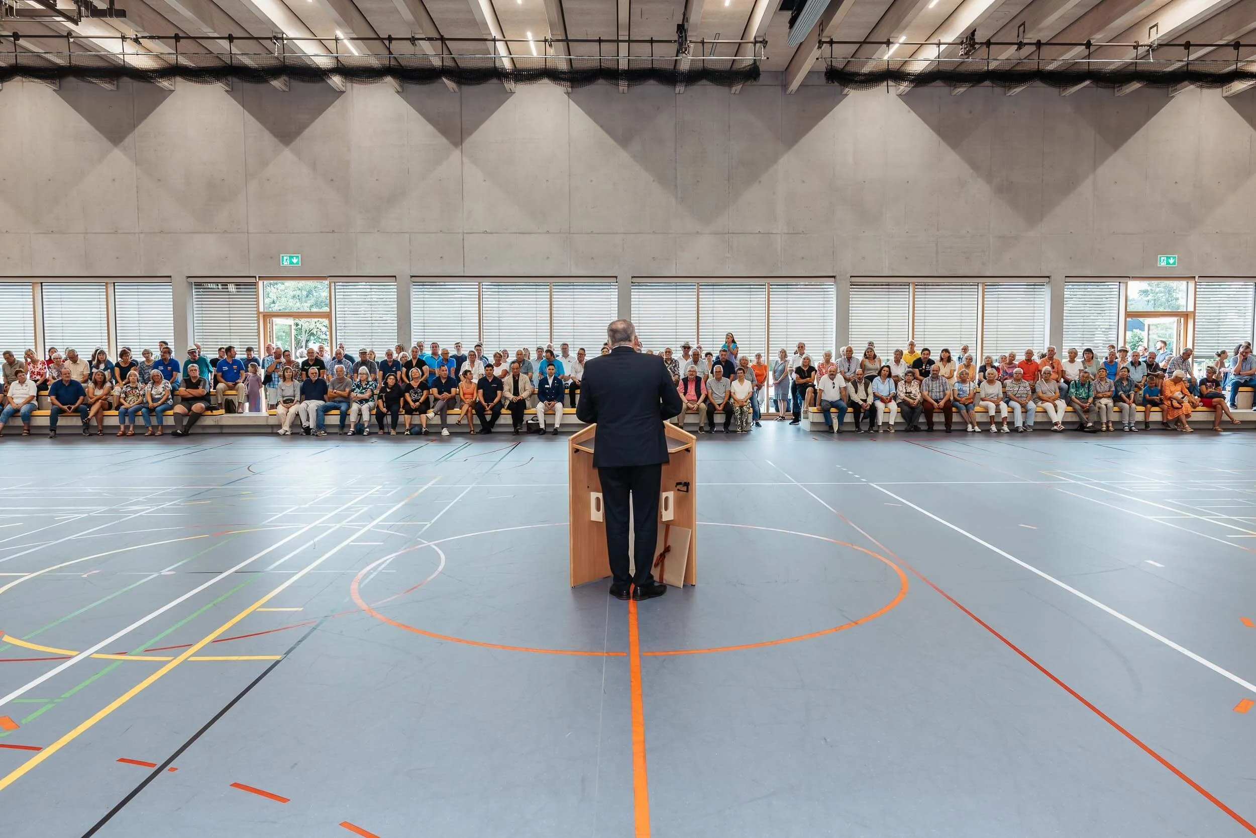 Eventfotografie Potsdam: Redner am Pult vor vollen Rängen bei der Eröffnung der Sporthalle am Lützelbach in Reichenbach an der Fils