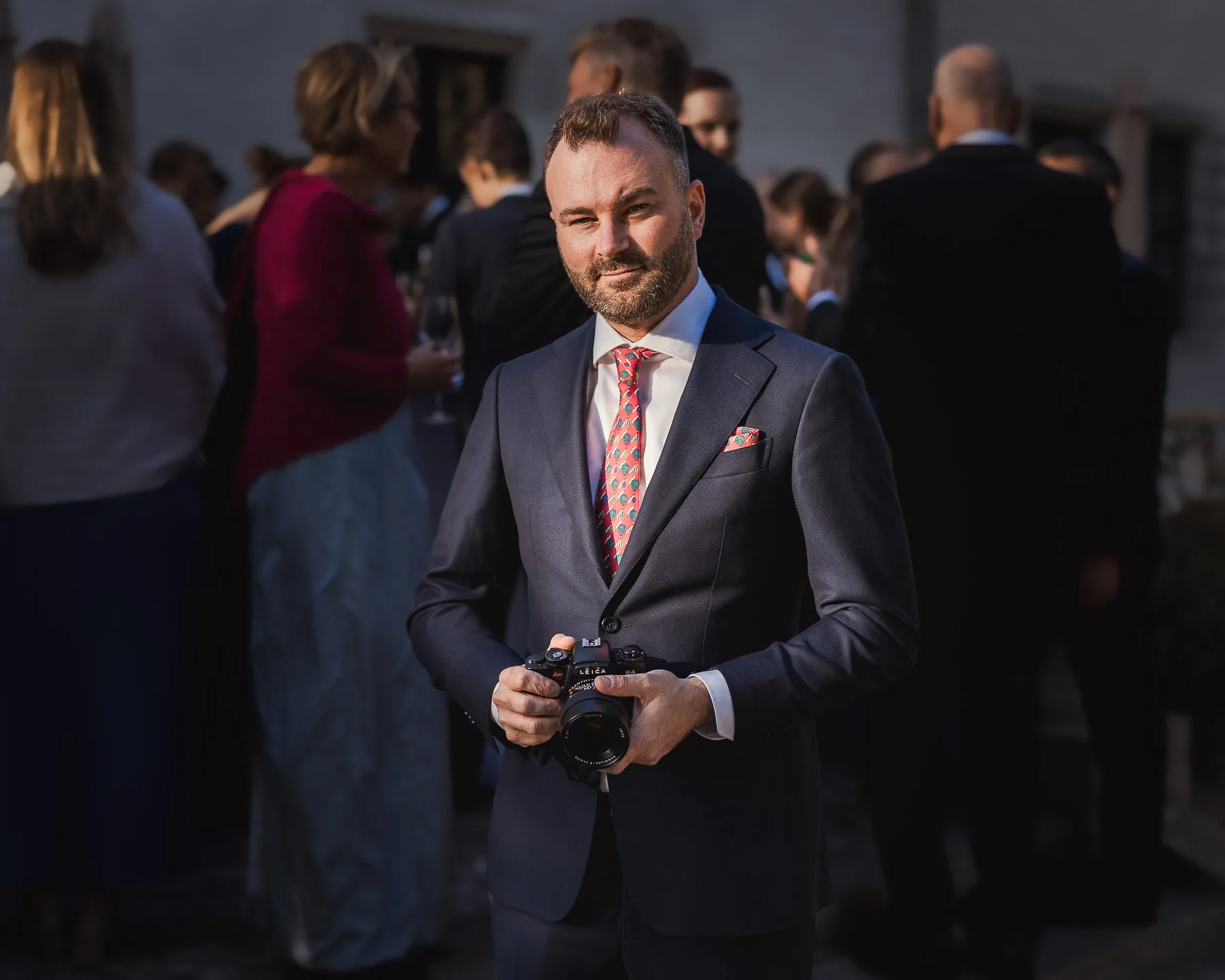 Businessfotograf Berlin: Maximilian von Alvensleben mit Leica-Kamera im Abendlicht bei einer Veranstaltung