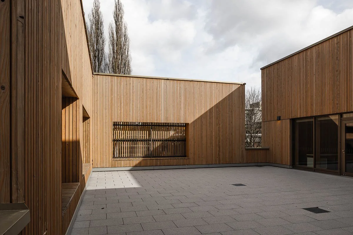 Architekturfotograf Berlin: Innenhof auf der Dachterrasse der Sporthalle am Lützelbach mit Holzfassade und Glastür zum Innenraum