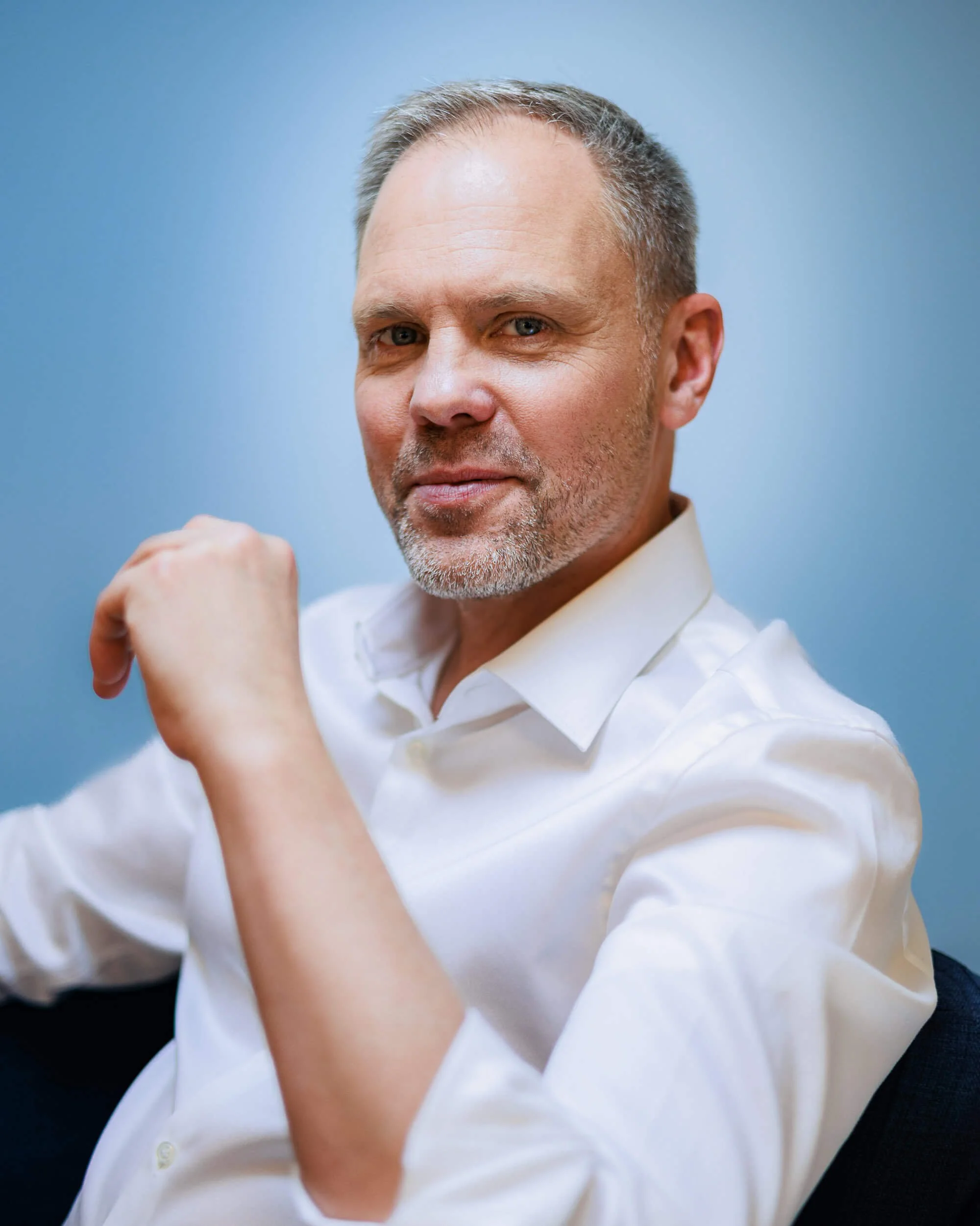 Businessfotograf Berlin: Thomas Dürst als Halbfigur mit ruhigem Blick vor Studiohintergrund
