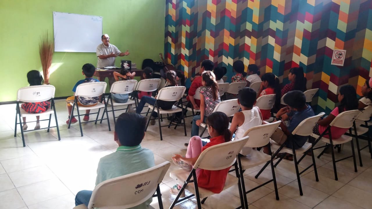 Niños recibiendo clases de su maestro.jpeg