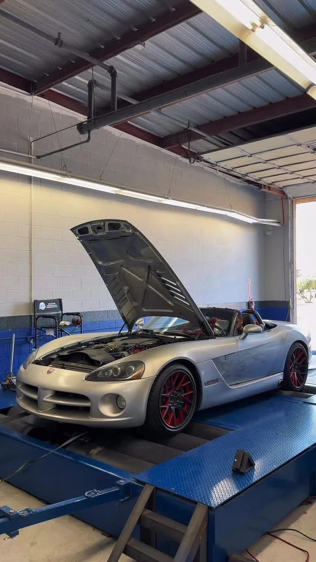 Silver Dodge Viper with its hood open on the shop dynamometer
