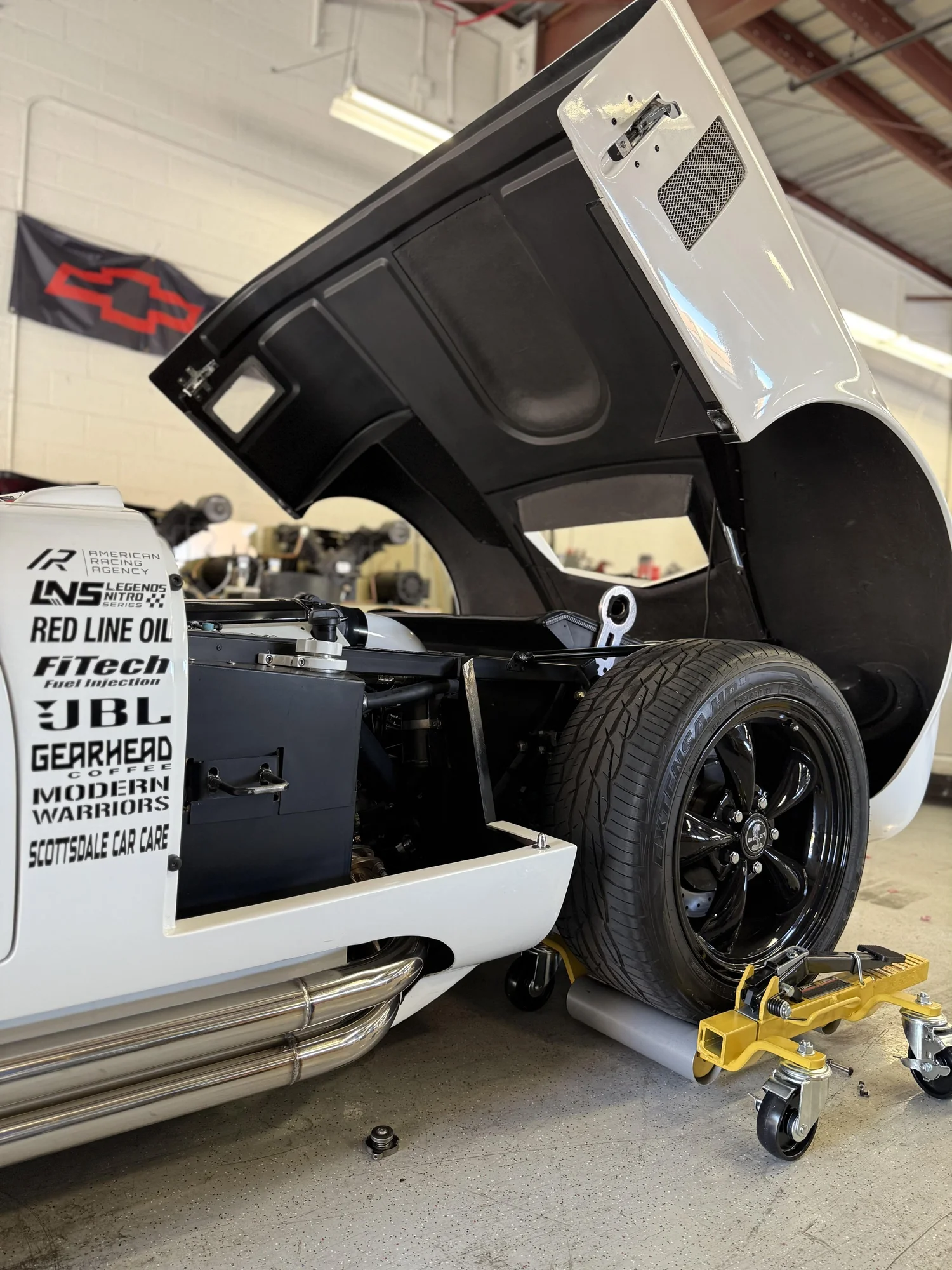 White Shelby-style roadster project inside Scottsdale Car Care and Speed Shop