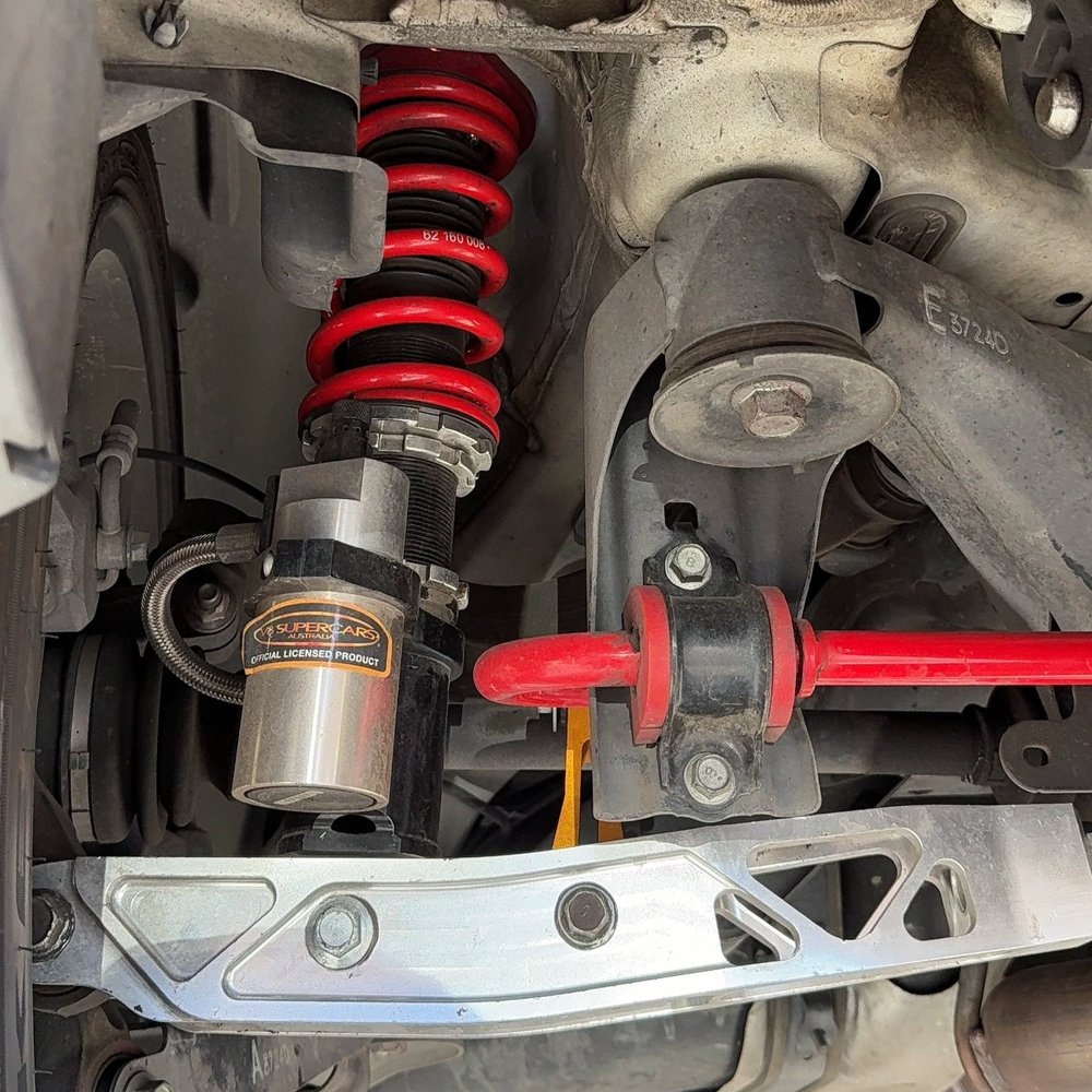 Upgraded coilover suspension and sway bar installed on a performance vehicle