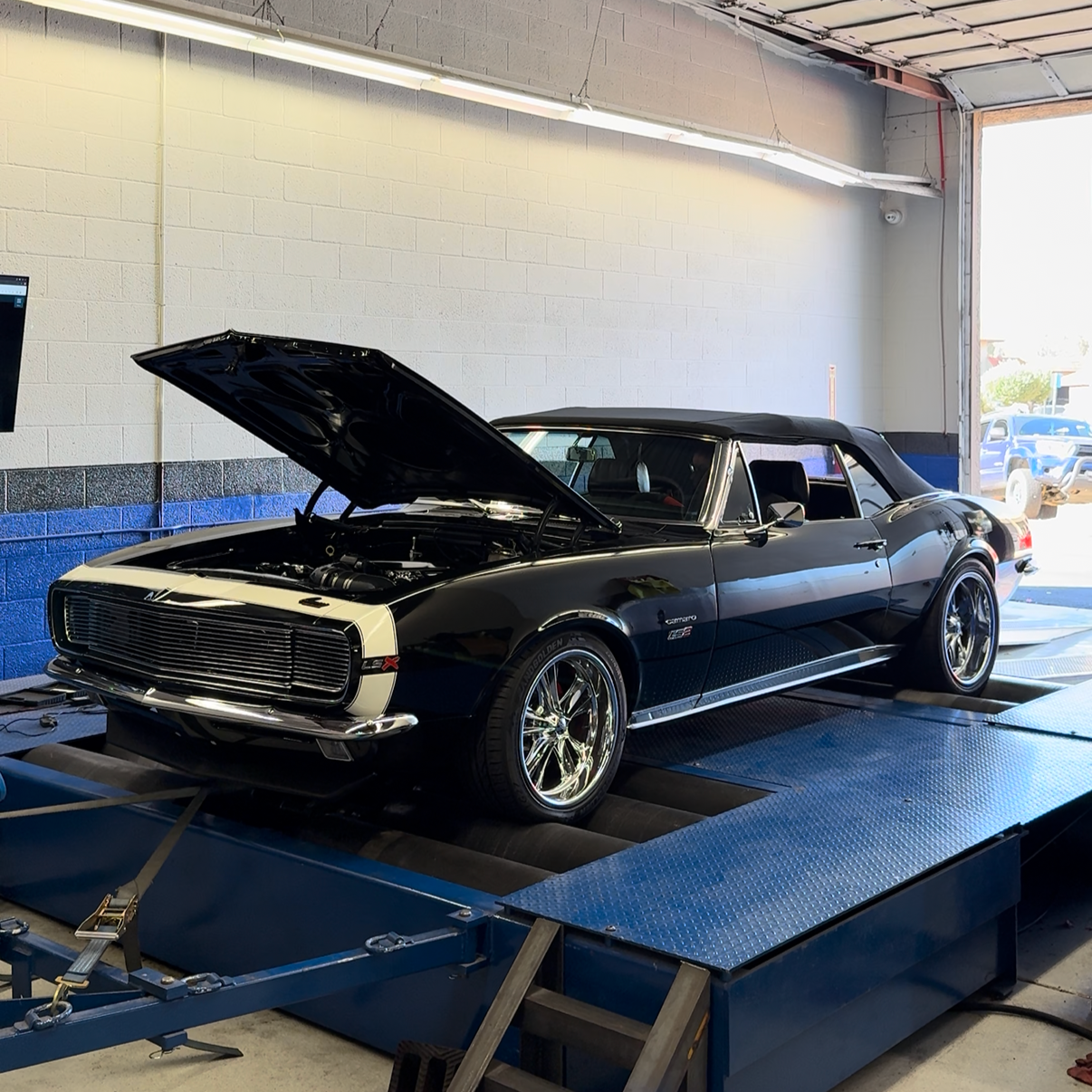 Classic black Chevrolet Camaro positioned on the shop dyno