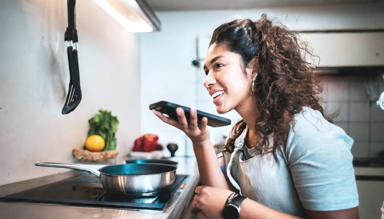 Una mujer realiza una búsqueda en Google Voice mientras cocina