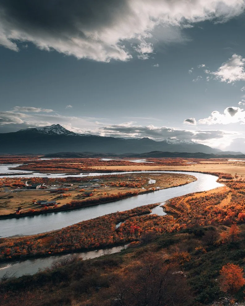 Río serpenteando por un paisaje de otoño con montañas al fondo, sur de Chile