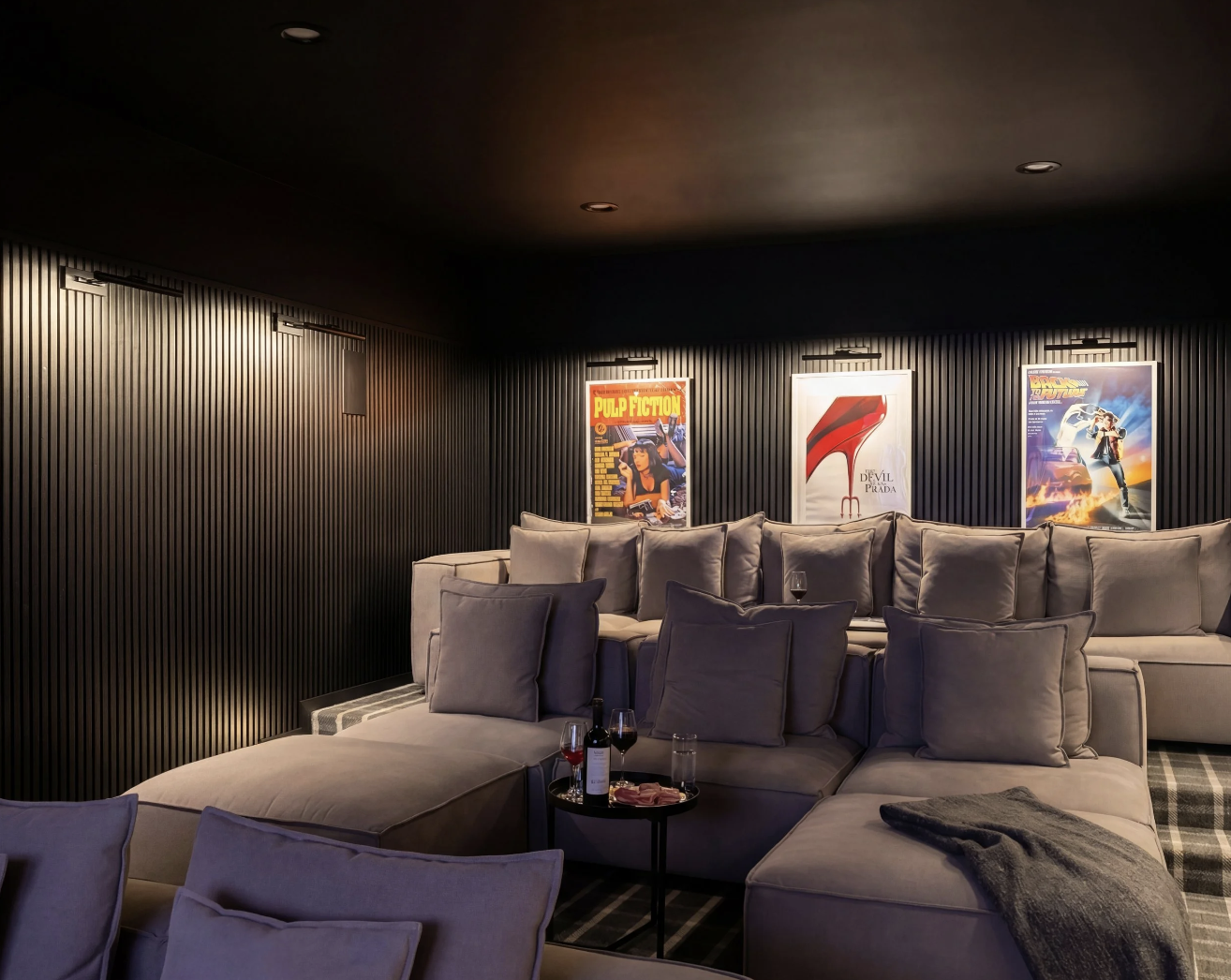 Custom home theatre in Hamptons residence with sectional seating and dark acoustic panel walls.