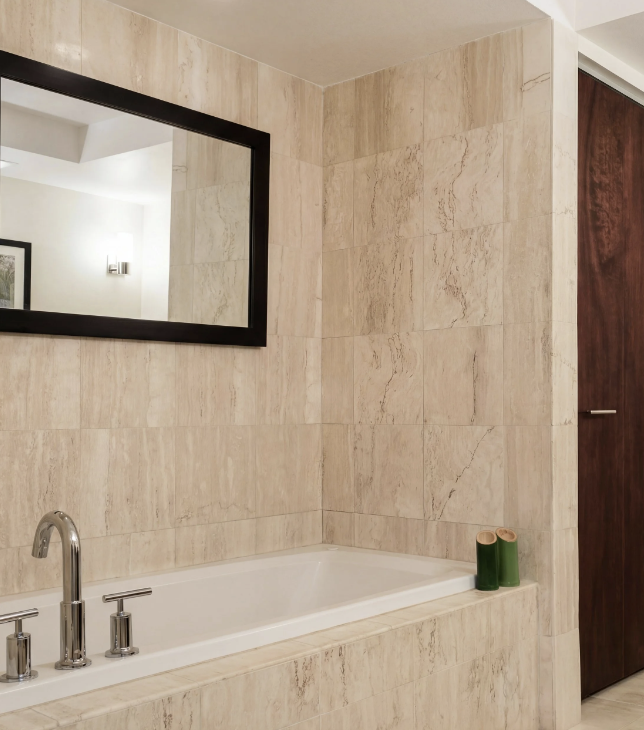 Updated Miami Beach condo bathroom with soaking tub and stone tile surround.