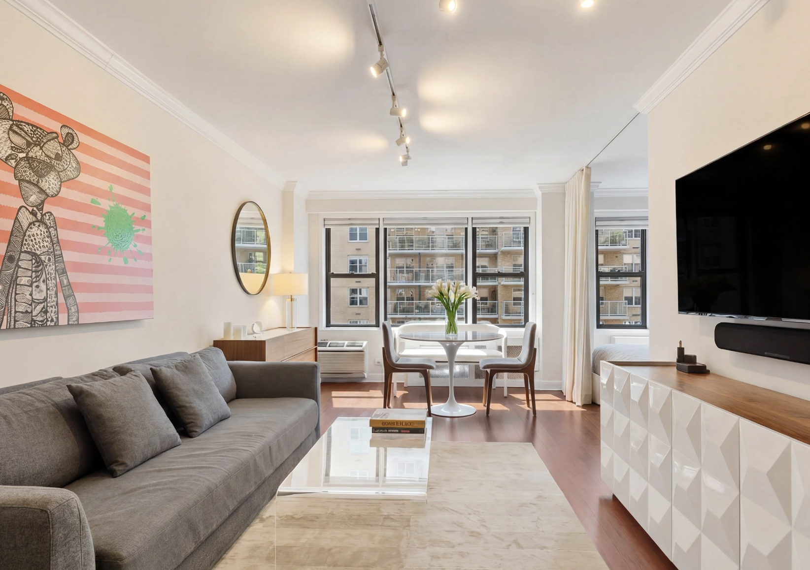 Modern Manhattan condo living room renovation with custom media console and city views.