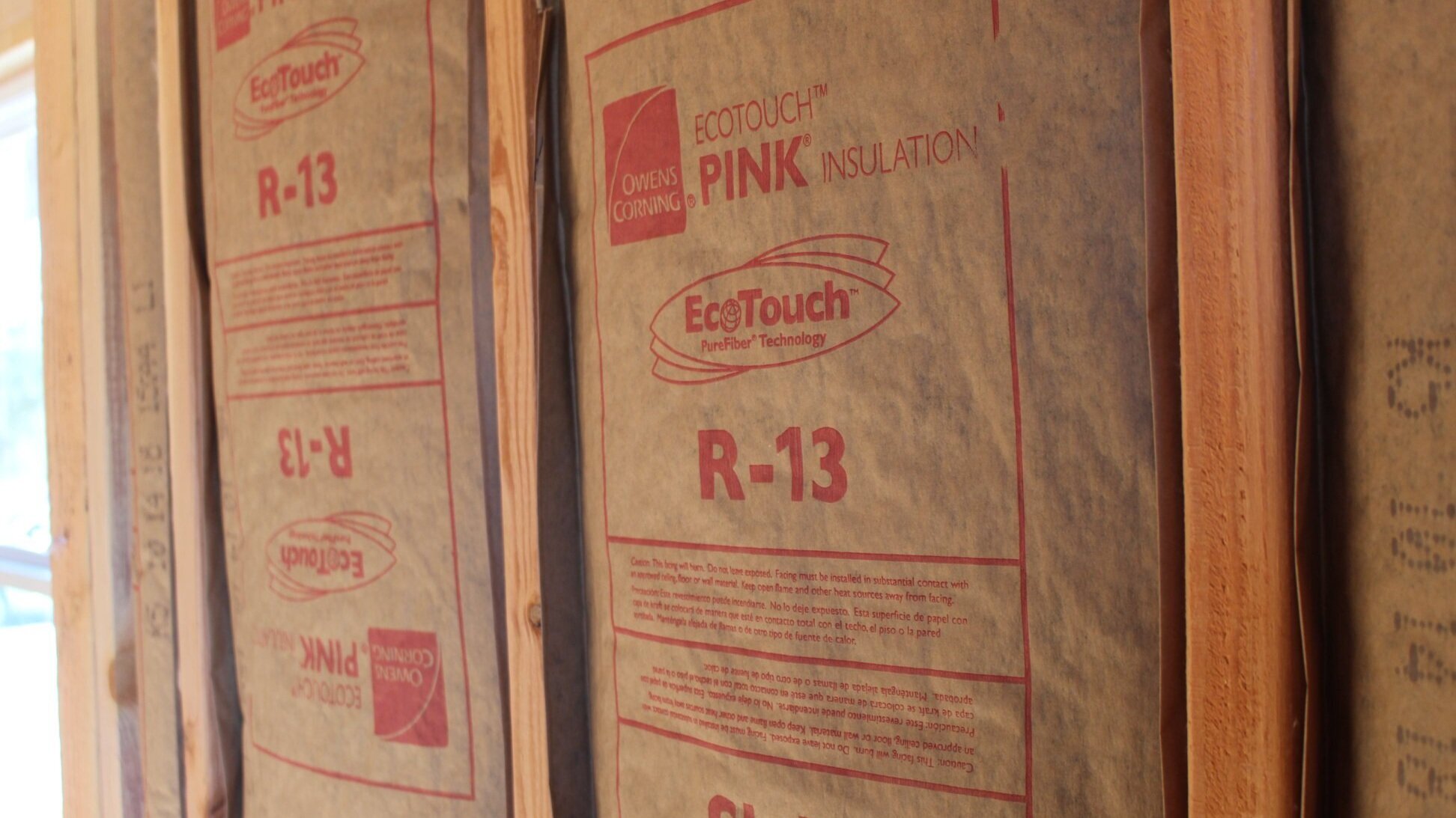 Freshly installed fiberglass batt wall insulation, contributing to enhanced thermal efficiency.