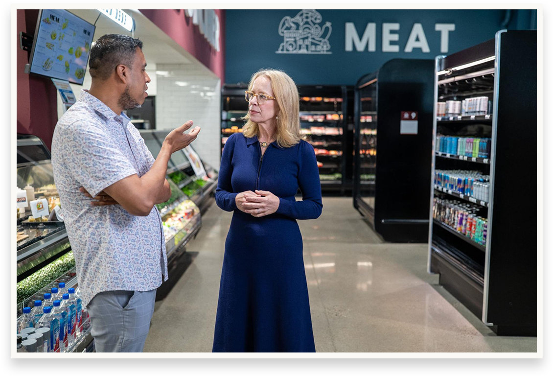 Kelly listening to a grocery store owner in his store