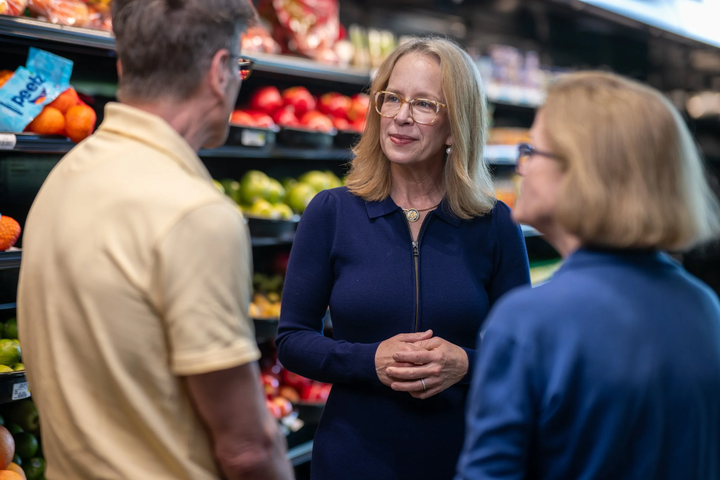 Kelly listening to a couple in a grocery store.