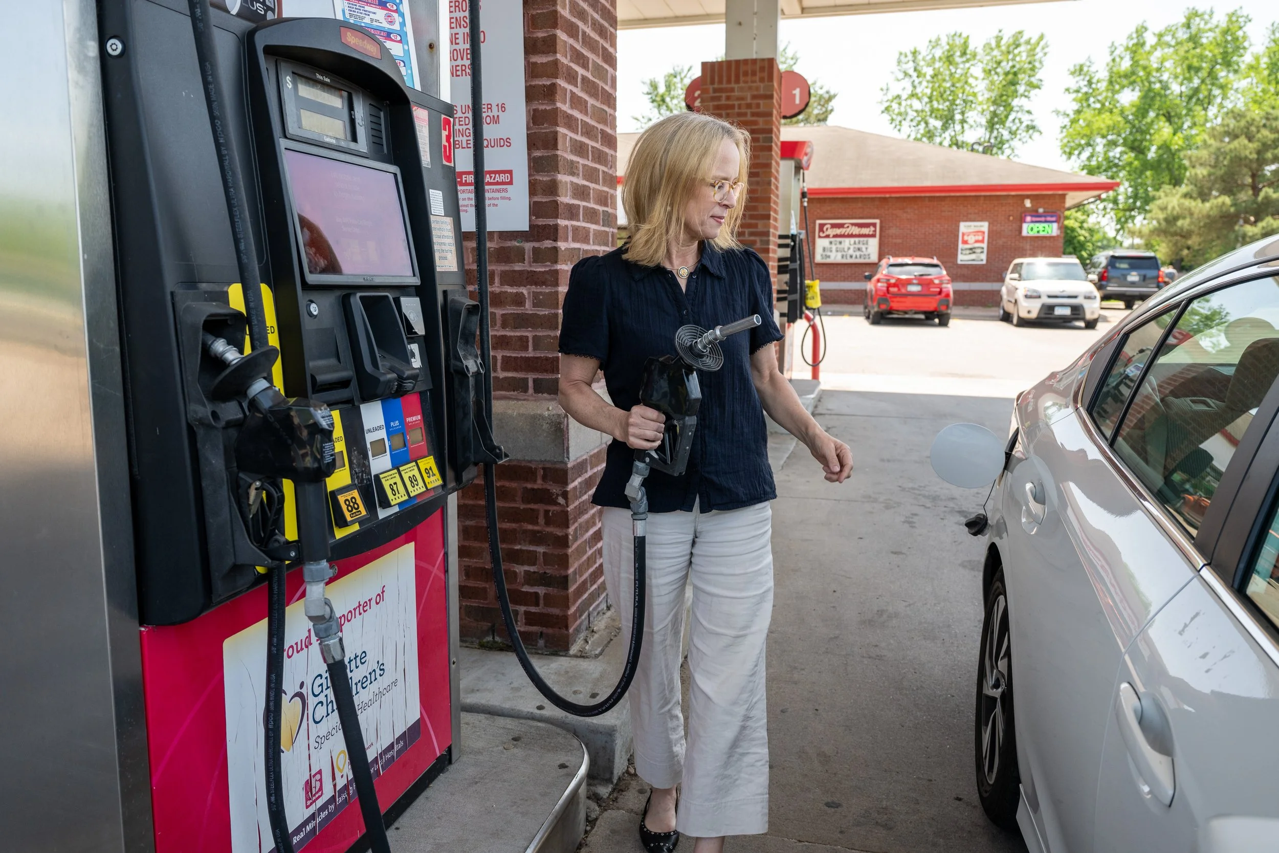 Kelly filling her car with gas.