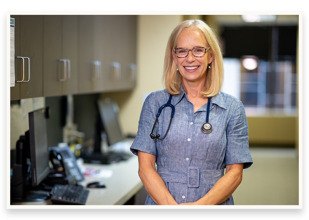 Photo of Kelly Morrison at her health clinic wearing a stethoscope.