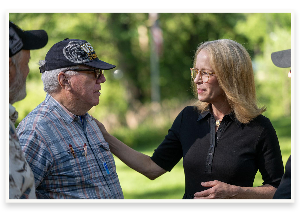 Kelly talking with veterans outside in a park
