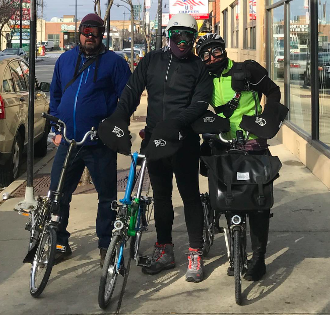 two men and a woman wearing goggles with Brompton bikes