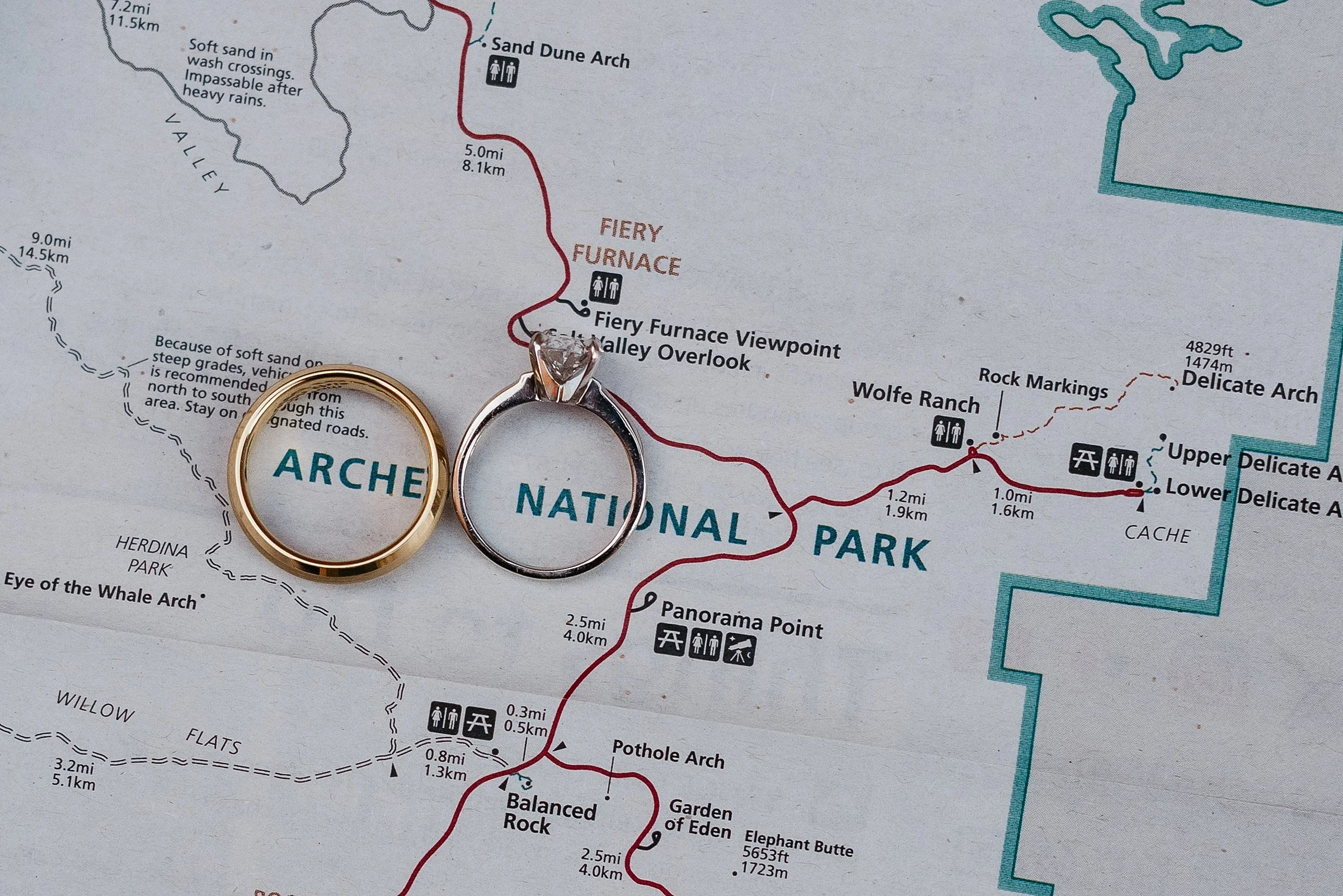 Two wedding rings are placed on top of an Arches National Park map.
