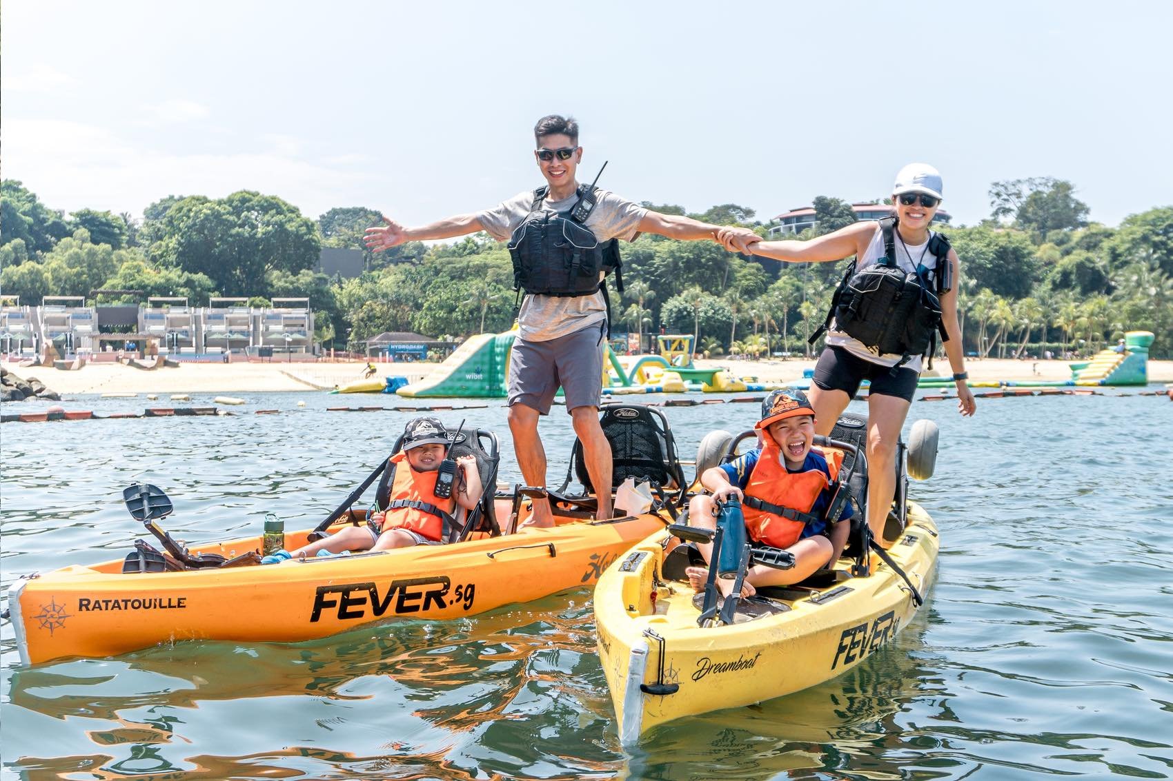 Mother and Father with 2 kids standing on Hobie compass duo kayak at Sentosa palawan beach