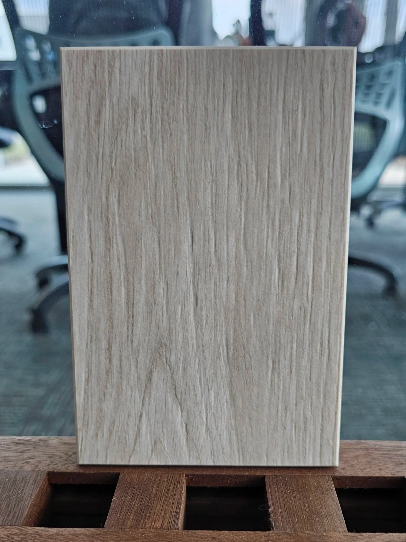 Close-up of Dekton Zira sample showing the light, creamy grain of the matte wood-look finish.