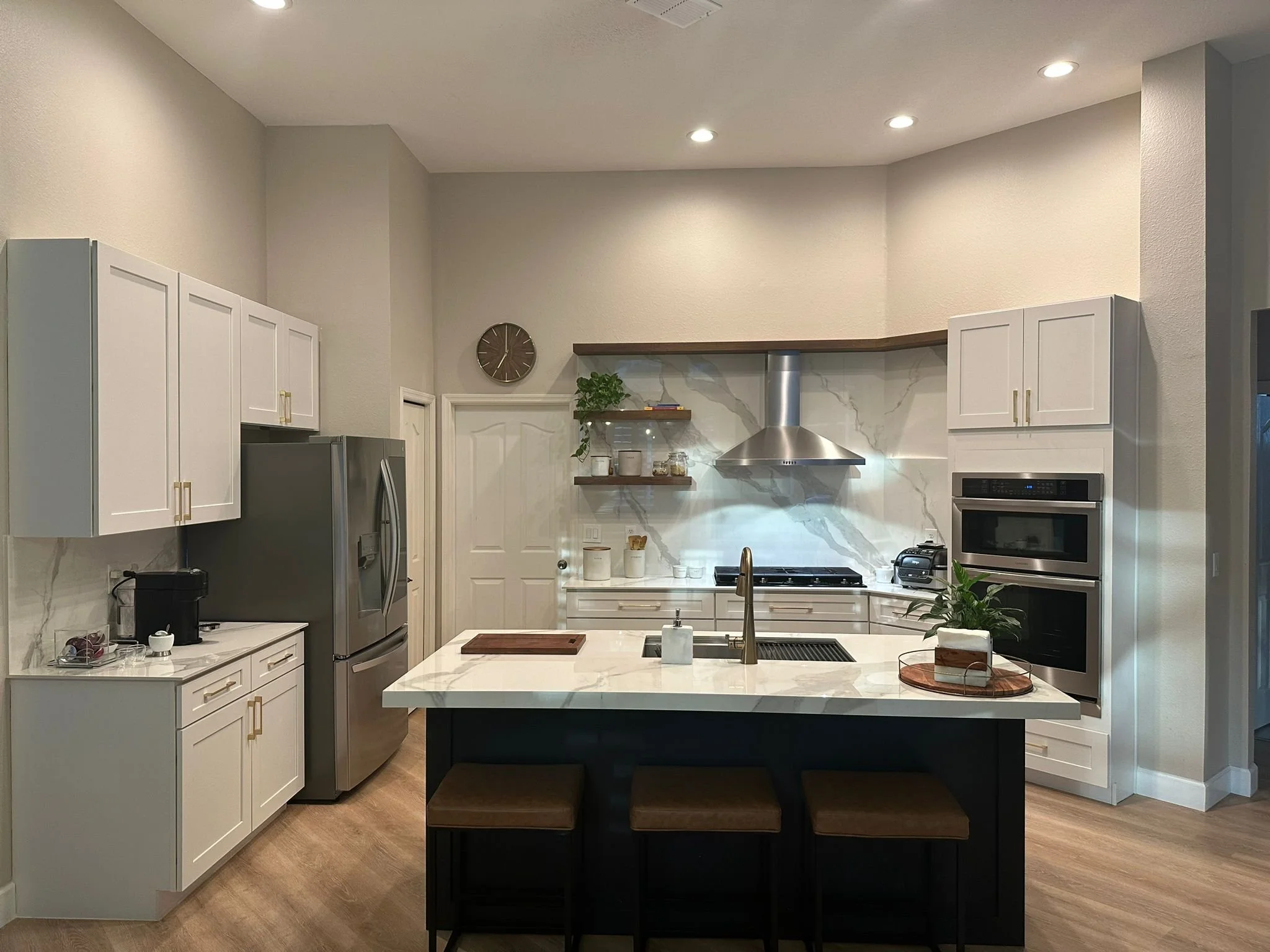 After photo of a finished Sarasota kitchen remodel featuring a marble look porcelain countertop and a matching full height slab backsplash behind the range hood.