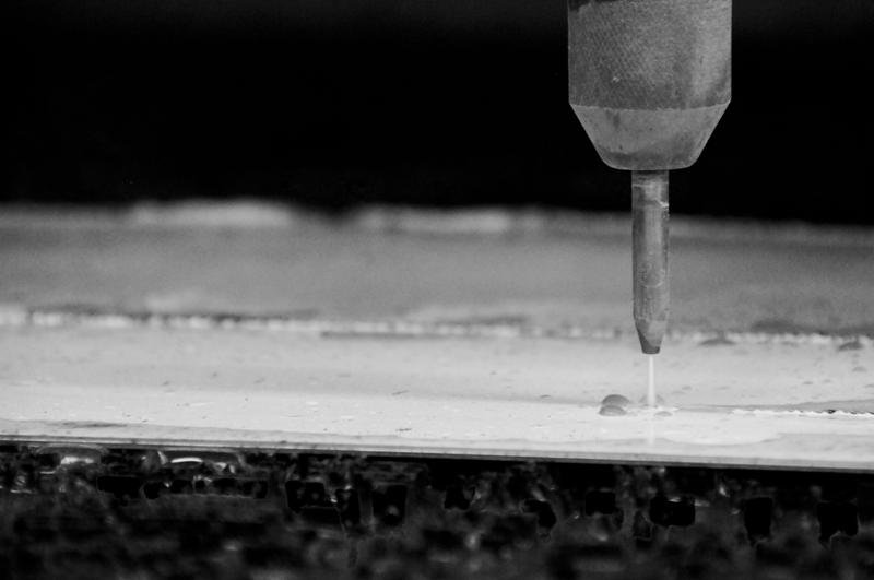 Image of a machine cutting a porcelain slab to create a fireplace.