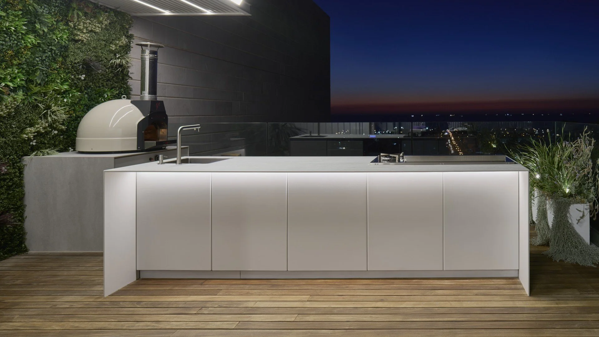 An elegant, modular outdoor kitchen framework showcasing custom grill cutouts and seamless storage doors by Capo Cuoco.