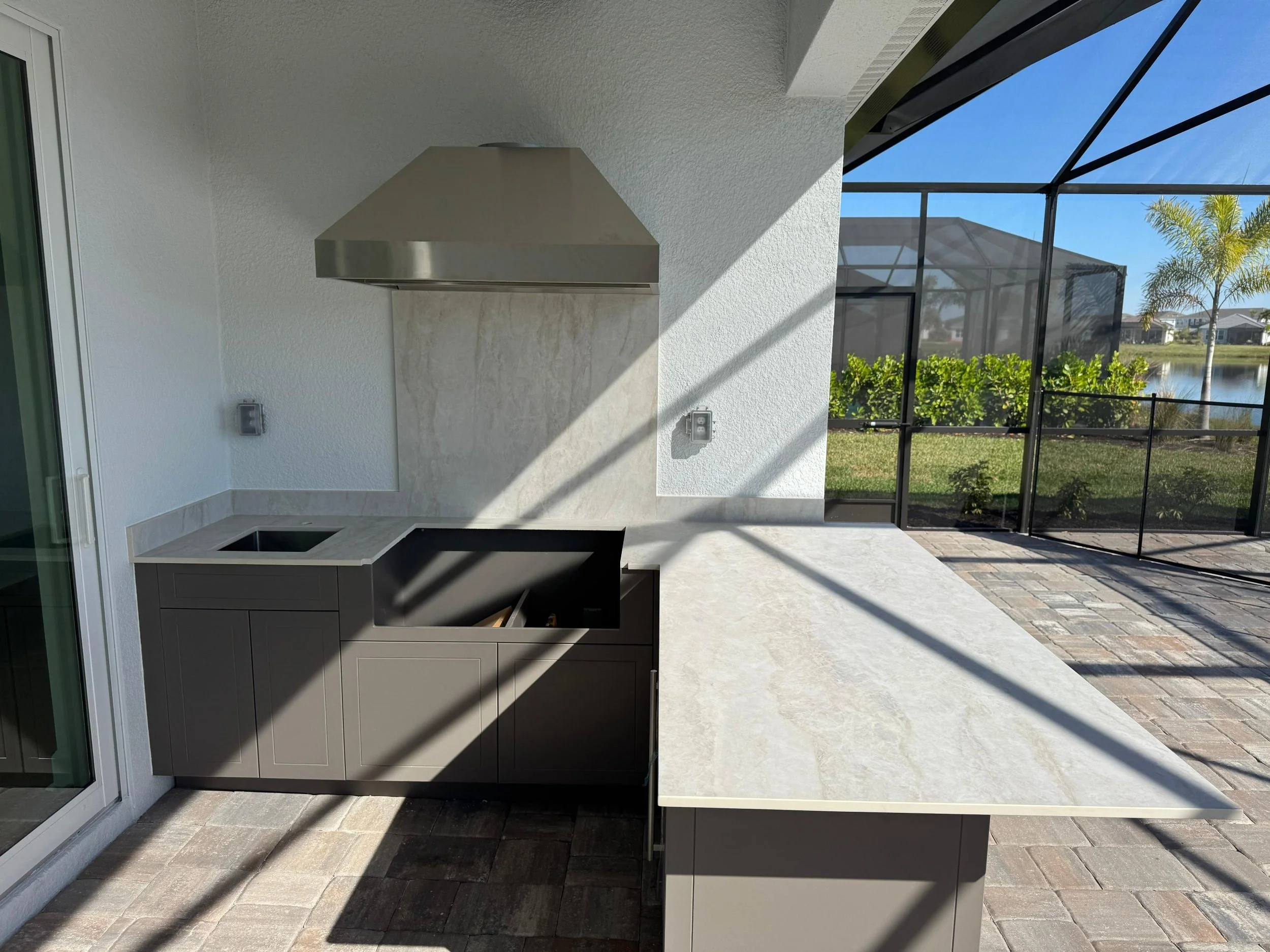 Custom Sarasota outdoor kitchen with a 2cm Dekton Nara countertop and matching full-slab backsplash, inspired by Taj Mahal quartzite.