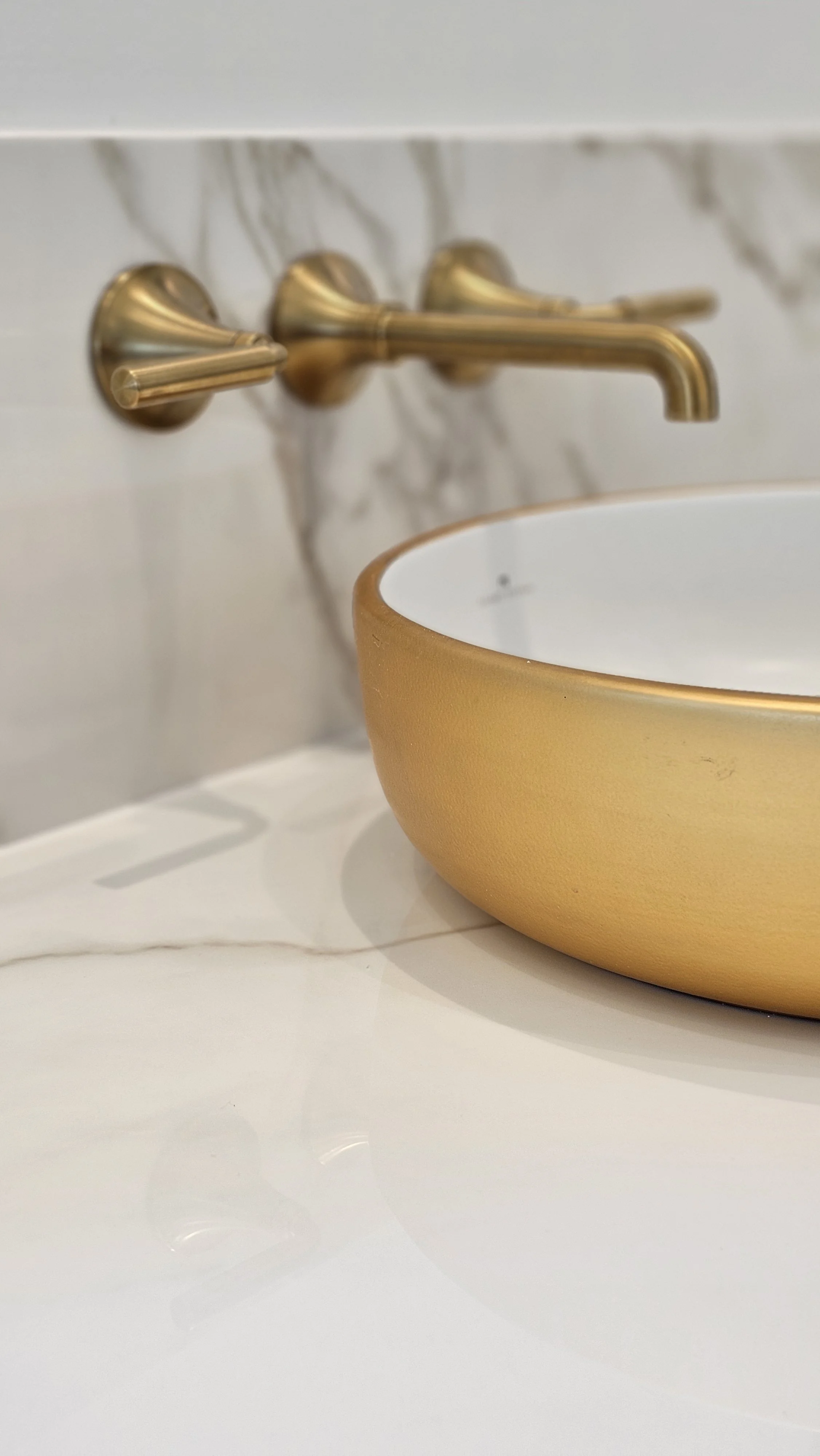 Elegant marble look porcelain slab used for full-height backsplashes in bathrooms behind a floating double vanity.
