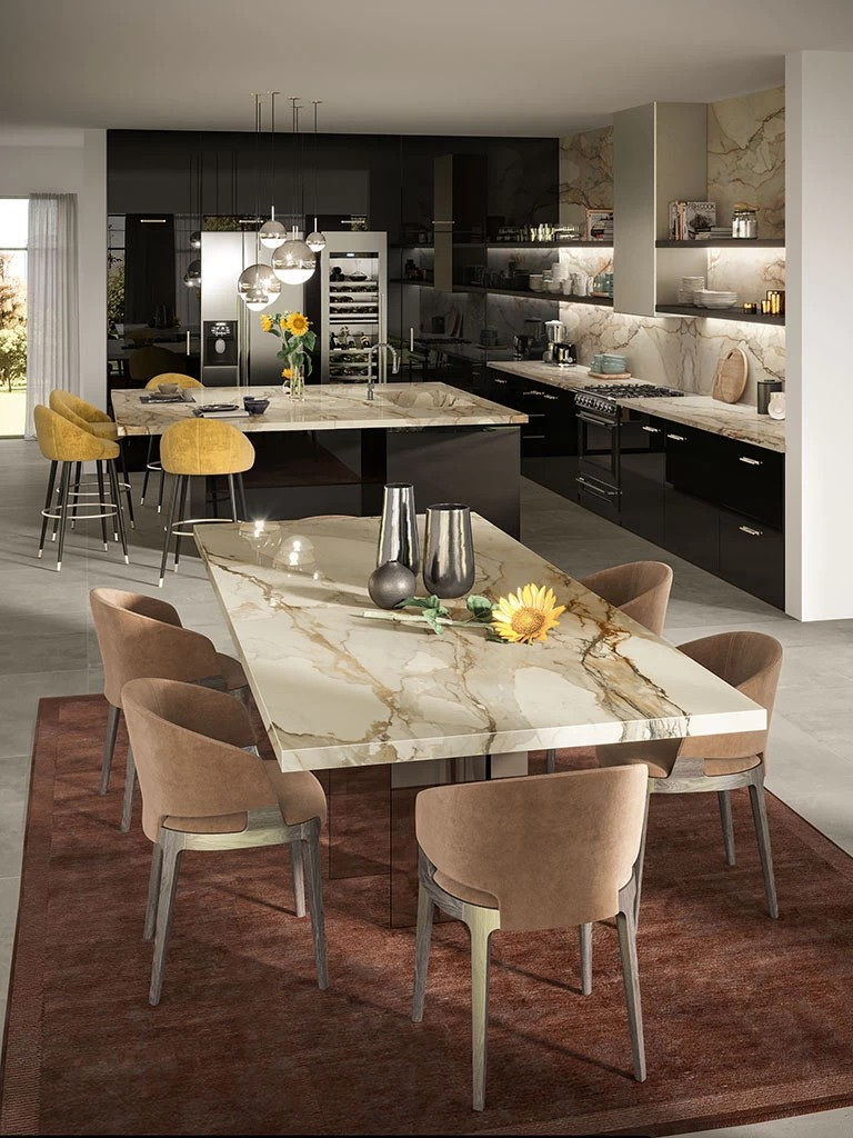 The countertop, backsplash, and dining table all feature the same stunning material (porcelain stoneware), creating a cohesive and luxurious surface aesthetic.