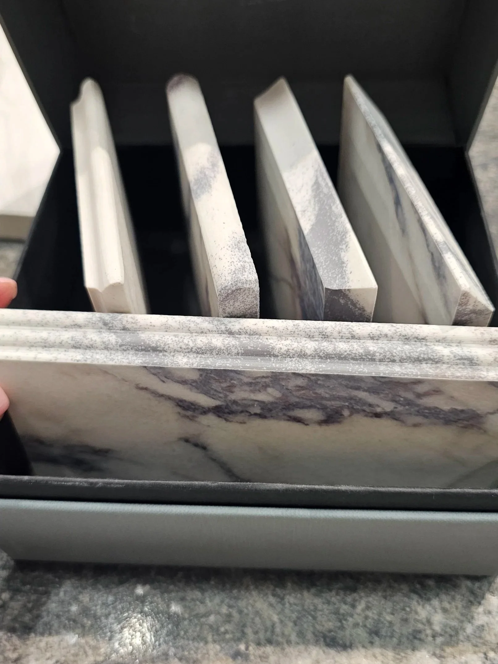 Sapienstone 4D technology samples showing through-body veining on porcelain slab edges, illustrating consistent pattern integration for mitered and eased edges.