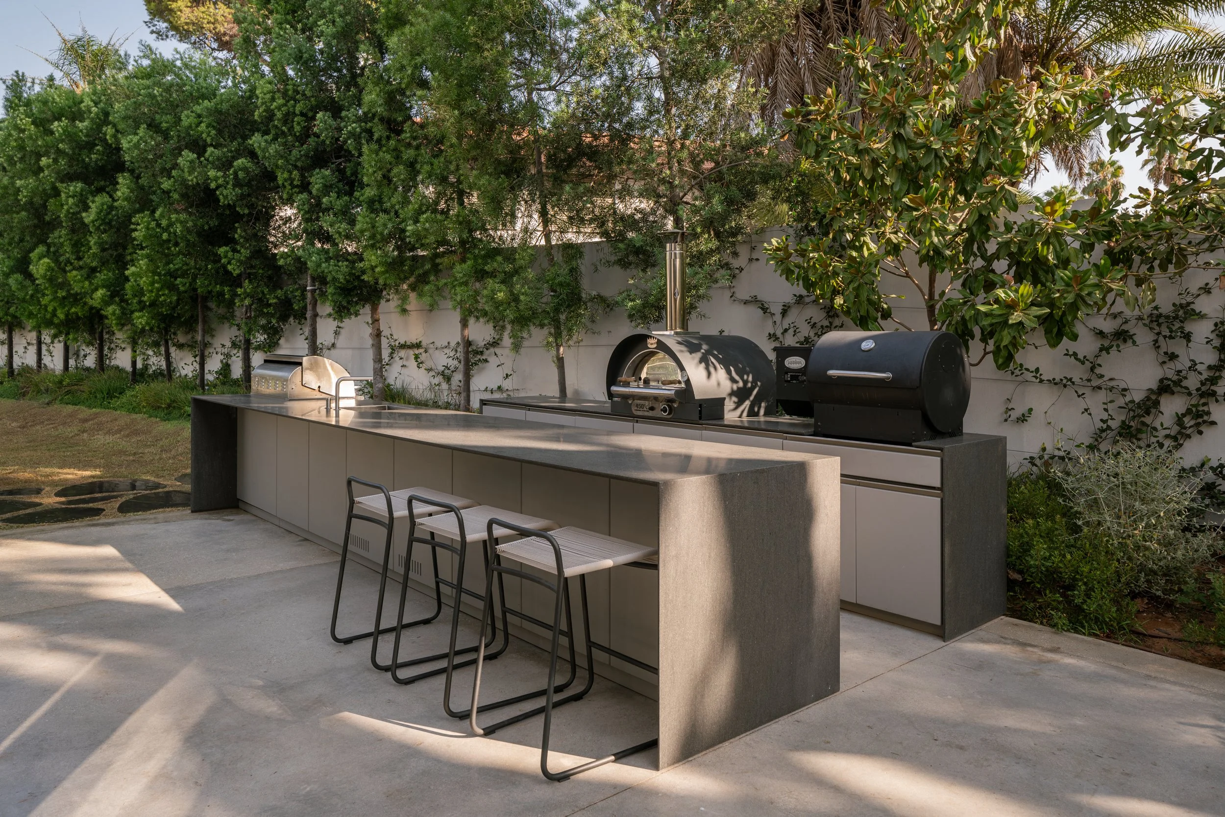 A fully customized, luxury modular outdoor cabinetry layout featuring integrated grilling modules and premium storage doors on Anna Maria Island.